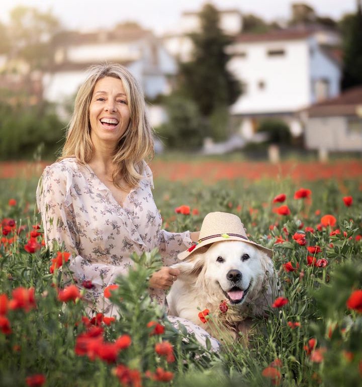 Una mujer y su perro golden retriever de excursión en Cataluña en el campo de amapolas